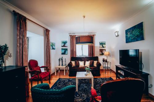 a living room with a couch and a tv at Casas do Prior in Trevões