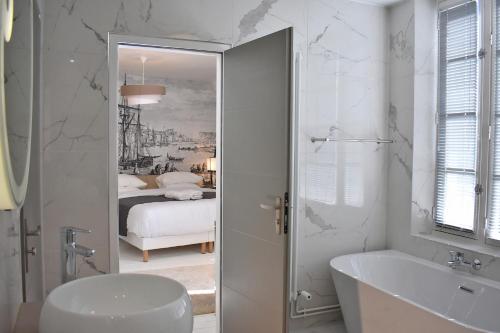 La salle de bains blanche est pourvue d'une baignoire et d'un lavabo. dans l'établissement Villa Castel Chambres d'hôtes B&B, à Dieppe