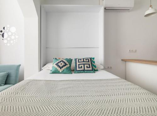 Un dormitorio con una cama blanca con almohadas. en Navy by Seaside Homes en Castelldefels