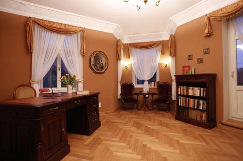 a home office with a desk and a book shelf at Villa Hierschel Droyßig in Droyßig
