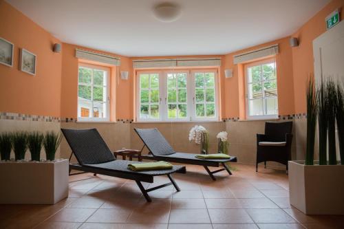 una sala d'attesa con due sedie e finestre di Pension Villa-Ingeborg a Fürstenberg/Havel