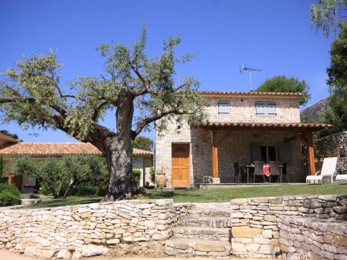 une maison en pierre avec un arbre devant dans l'établissement Villa Sanchez, à Bonifacio