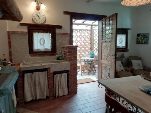 a living room with a brick fireplace and a clock on the wall at Cascina Bricco in Ovada