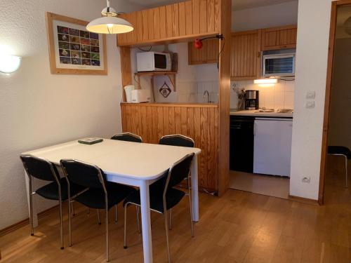 une cuisine et une salle à manger avec une table et des chaises dans l'établissement VAUJANYLOCATIONS - Cochette II Apt 1 & 2, à Vaujany