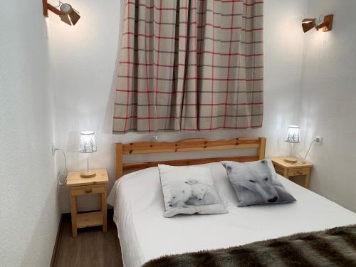une chambre avec un lit avec deux oreillers dessus dans l'établissement VAUJANYLOCATIONS - Cochette II Apt 12, à Vaujany