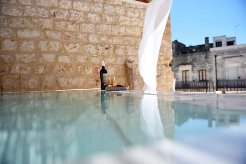 a bottle of wine sitting on the floor of a swimming pool at Arya Nobile Dimora in Carovigno