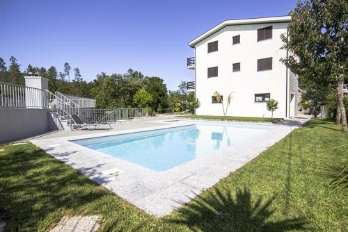 a swimming pool in a yard next to a building at Sousa Horizonte - Louredo in Vieira do Minho