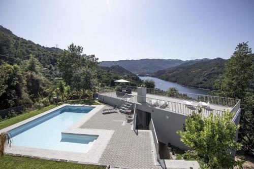 a house with a swimming pool next to a river at Sousa Horizonte - Louredo in Vieira do Minho