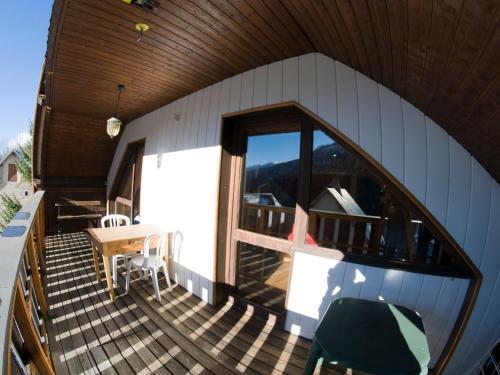 un balcon d'une maison avec une table et des chaises dans l'établissement VAUJANYLOCATIONS - Chalet Perin, à Vaujany