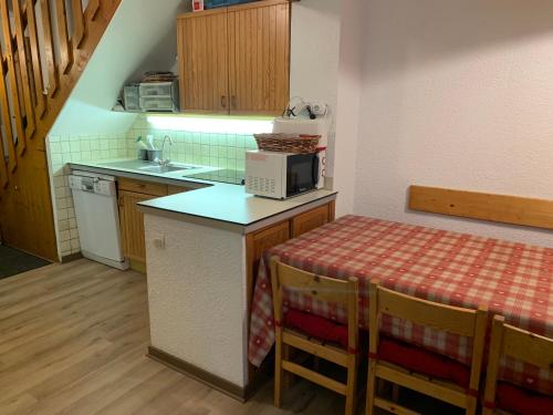 une petite cuisine avec une table et un évier dans l'établissement VAUJANYLOCATIONS - Claret II Apt 12, à Vaujany