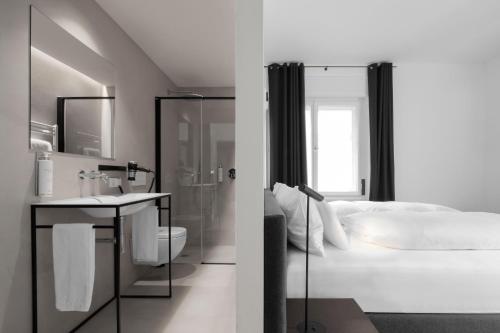 a white bathroom with a bed and a sink at Casa al Sole in Ortisei