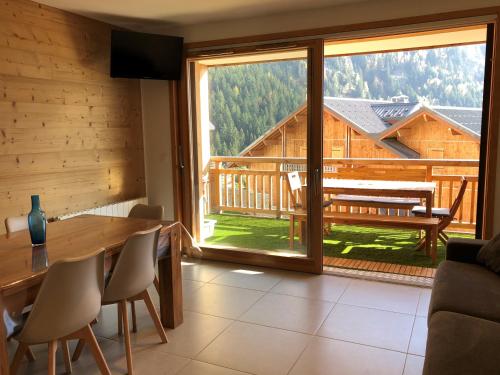 un salon avec une table et une grande fenêtre dans l'établissement VAUJANYLOCATIONS - Domaine du Pâtre, à Vaujany