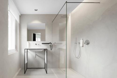 a bathroom with a glass shower and a sink at Casa al Sole in Ortisei