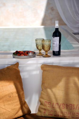 a bottle of wine and two glasses on a table at Arya Nobile Dimora in Carovigno