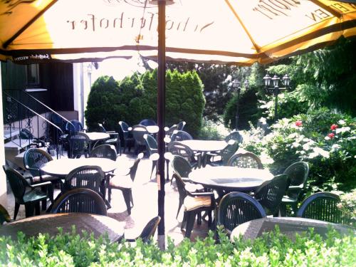 a group of tables and chairs under an umbrella at Landgasthaus Waldesruh in Welschneudorf