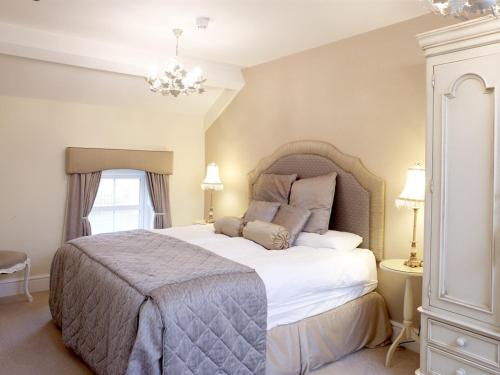 a bedroom with a large bed and a chandelier at Wall Hill Farm in Northwich
