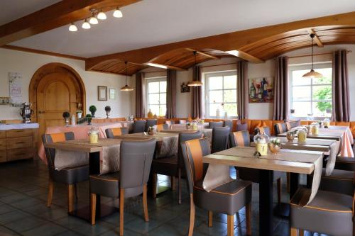 una sala da pranzo con tavoli e sedie in legno di Hotel-Weinhaus Stettler a Lieser