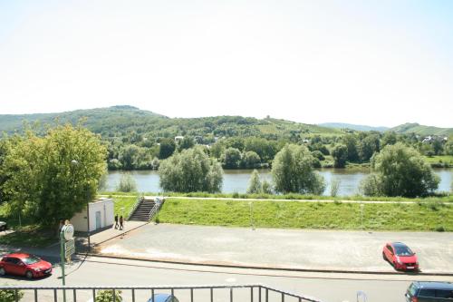 a parking lot with two cars parked next to a river at Hotel-Weinhaus Stettler in Lieser