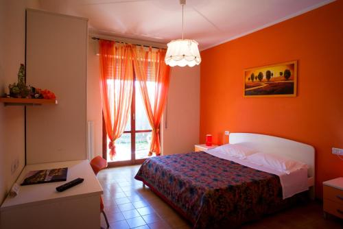 sypialnia z pomarańczowymi ścianami i łóżkiem z oknem w obiekcie BED AND BREAKFAST SAPORE DI MARE A 50 MT dalla SPIAGGIA w mieście Grottammare