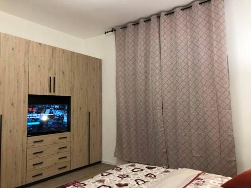 una camera con letto, TV e tenda di Appartamento Daniela a Calenzano