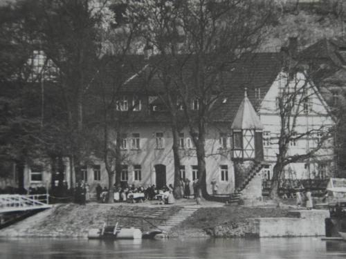 una foto in bianco e nero di una casa vicino al fiume di Zum Weserdampfschiff a Bad Karlshafen