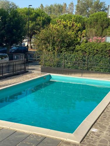 a large blue swimming pool in a parking lot at Hotel Rex in Lido di Savio