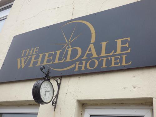 a sign for the waldale hotel on a building with a clock at Wheldale Hotel-Bed and Breakfast in Castleford