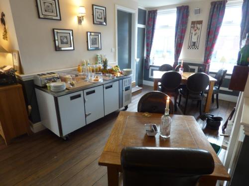 a kitchen with a table and a counter with chairs at Wheldale Hotel-Bed and Breakfast in Castleford