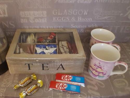 a tea box and a cup of coffee and some candy at White Guest House in Bath