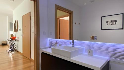 a bathroom with a white sink and a mirror at Madeira Mero Apartment in Caniço