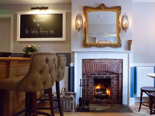 a living room with a fireplace and a mirror at The White Horse Inn in Pulborough