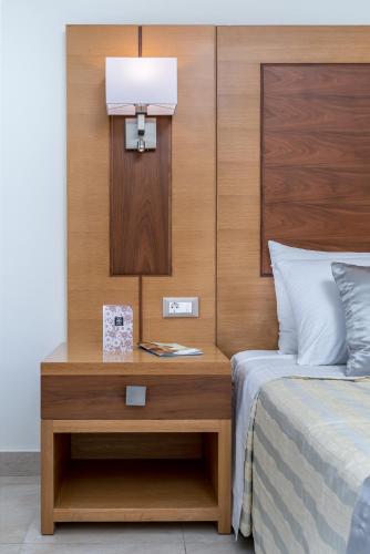a bedroom with a bed and a nightstand with a lamp at Apollo Blue in Faliraki