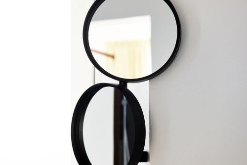 a mirror with a black frame on a wall at Arya Nobile Dimora in Carovigno