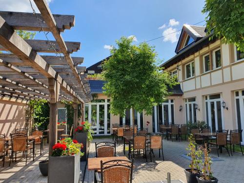a patio with tables and chairs and a building at Landgasthof Winzerscheune in Valwig