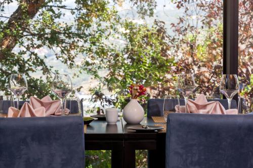 a table with chairs and a table with wine glasses at Douro Palace Hotel Resort & SPA in Baião