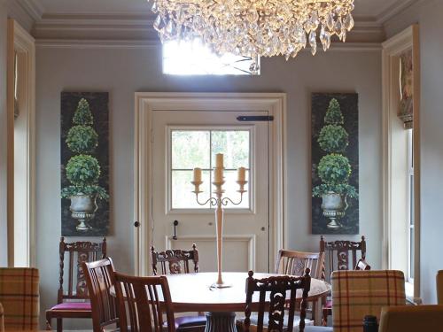 a dining room with a table and chairs and a chandelier at Woodberry Inn in Bridgnorth
