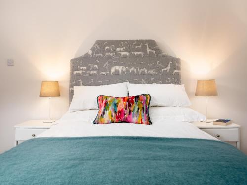 a bedroom with a large bed with a colorful pillow at Woodcock Farm in Bristol