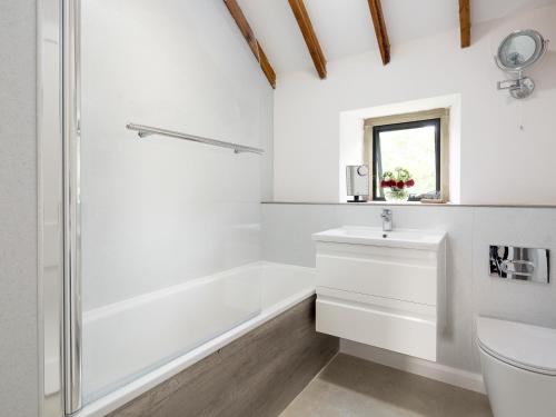 a white bathroom with a shower and a sink at Woodcock Farm in Bristol