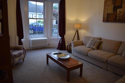 a living room with a couch and a coffee table at Woodlyn Guest House in Gatehouse of Fleet