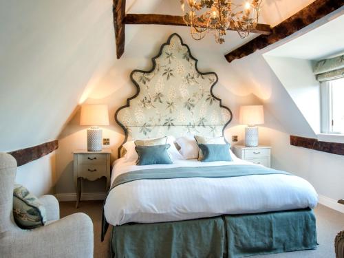 Un dormitorio con una cama grande y una lámpara de araña. en Woolmarket House en Chipping Campden