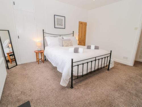 a bedroom with a large bed with white sheets at Cheviot Way Cottage in Wooler