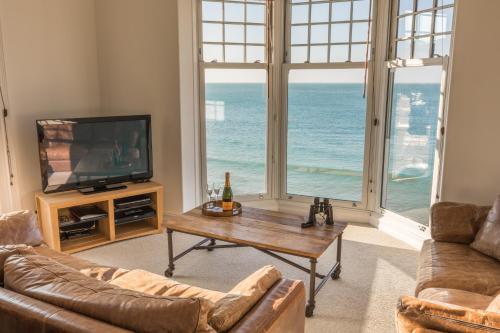 a living room with a view of the ocean at Water's Edge Apartment in Totland