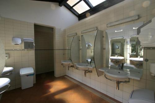 a public bathroom with three sinks and mirrors at Easyatent Safari tent Polari in Rovinj