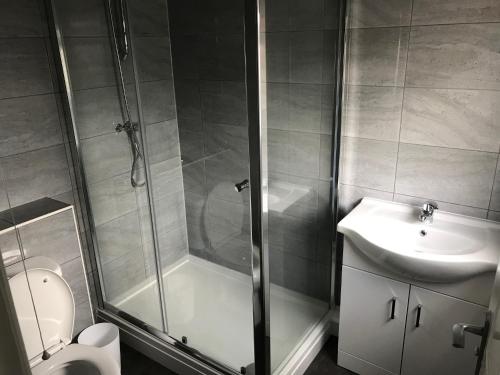 a bathroom with a shower and a toilet and a sink at K Stunning 5 Bed Sleeps 8 Families Workers by Your Night Inn Group in Wolverhampton