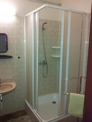 a shower with a glass door next to a sink at Penzion Menšík in Kroměříž