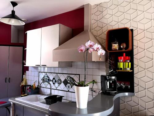 uma cozinha com um vaso com flores num balcão em Orval et Sens - Les Caudalies Studio em Orvault
