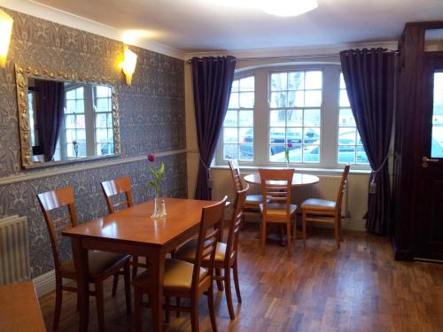 a dining room with a table and chairs and windows at Blarney Castle Hotel in Blarney