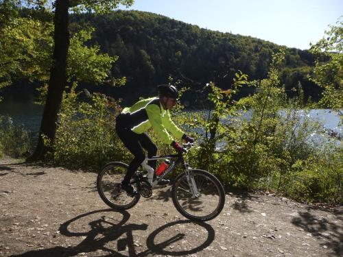 a man riding a bike on a path near a river at Hotel Zur Post in Klotten