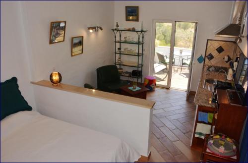 ein Schlafzimmer mit einem Bett und ein Zimmer mit einem Balkon in der Unterkunft Studio Casa Formosa in Olhão