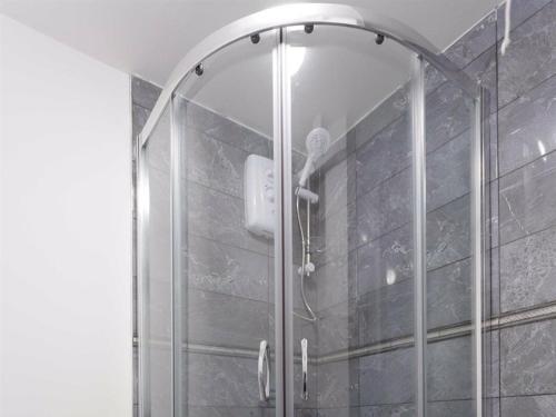 a shower with a glass door in a bathroom at Berkley Studio in Leeds